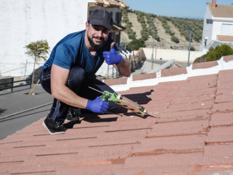 Roof leak repair cost process showing professional fixing damaged shingles and water leak on residential roof