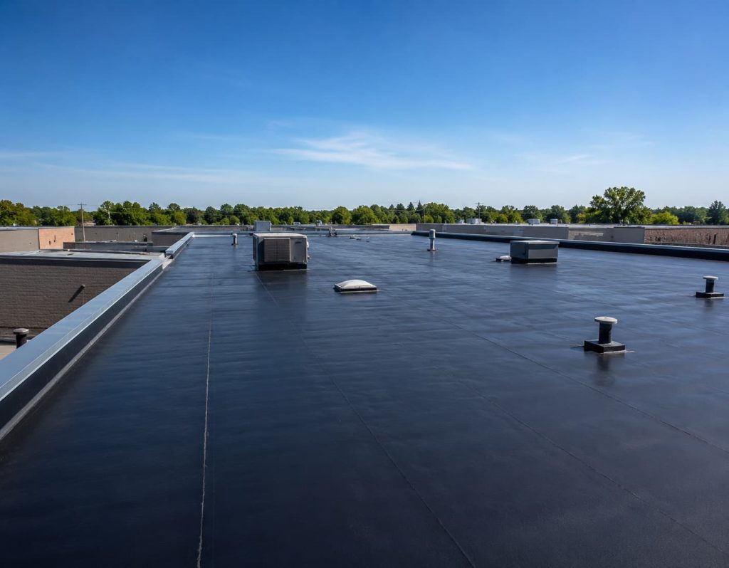 Commercial EPDM Roofing system installed on a large flat commercial building with a completed black roofing membrane